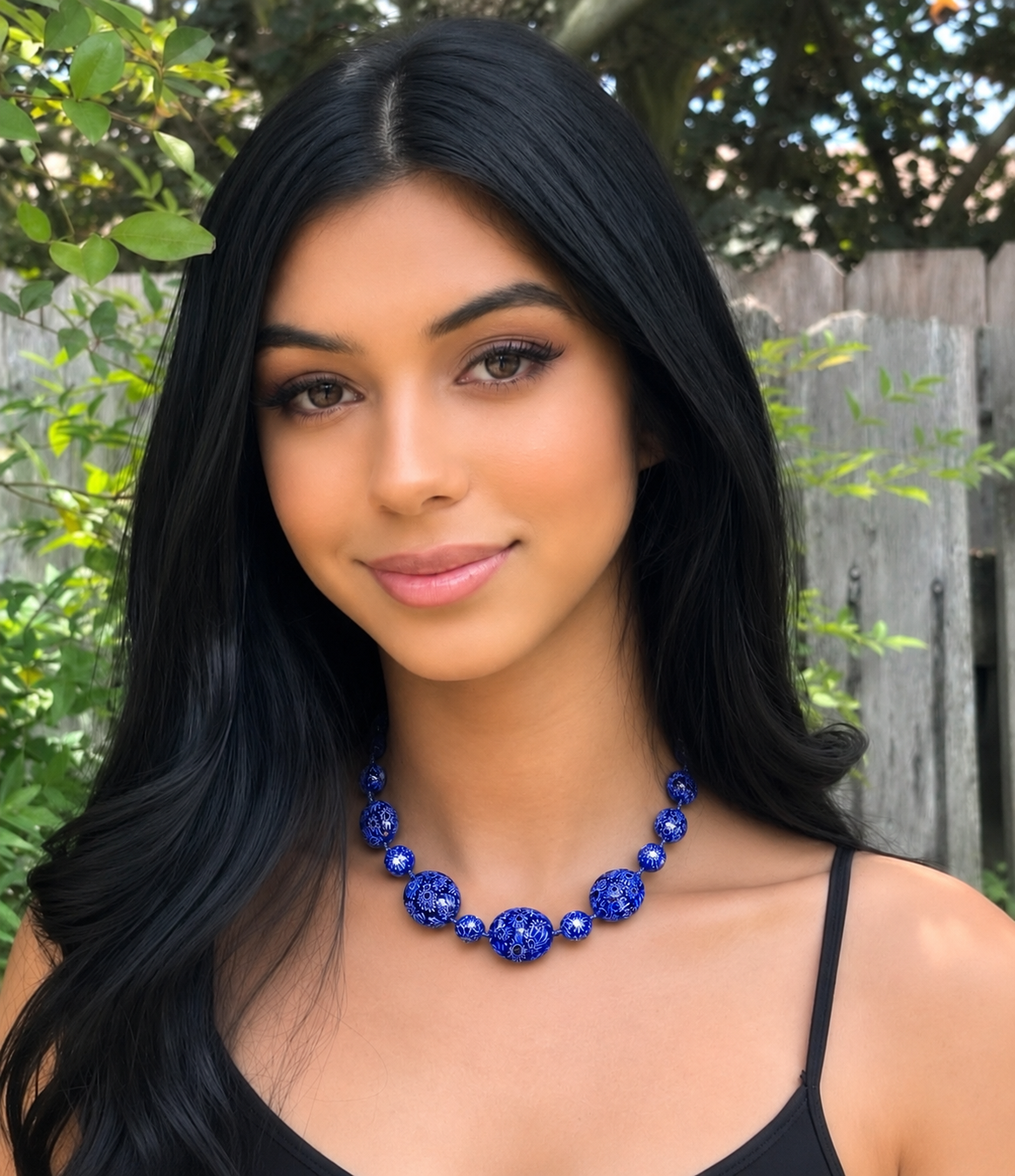 A woman wearing a blue Rosario Leonardi Murano glass necklace